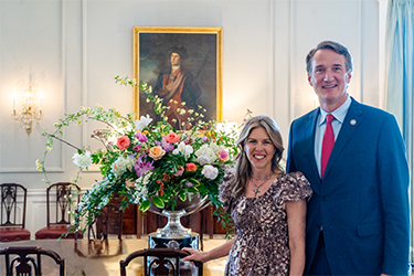 The Governor and First Lady pose with the Dining Room table arrangement.